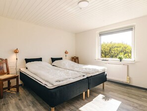 Una habitación con una cama, un ventanal y un radiador.