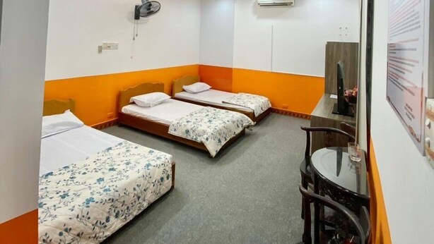 A hotel room with two single beds, a desk, and a chair. - Pham Gia Hotel Ha Giang - by Bay Luxury (Ha Giang 1)