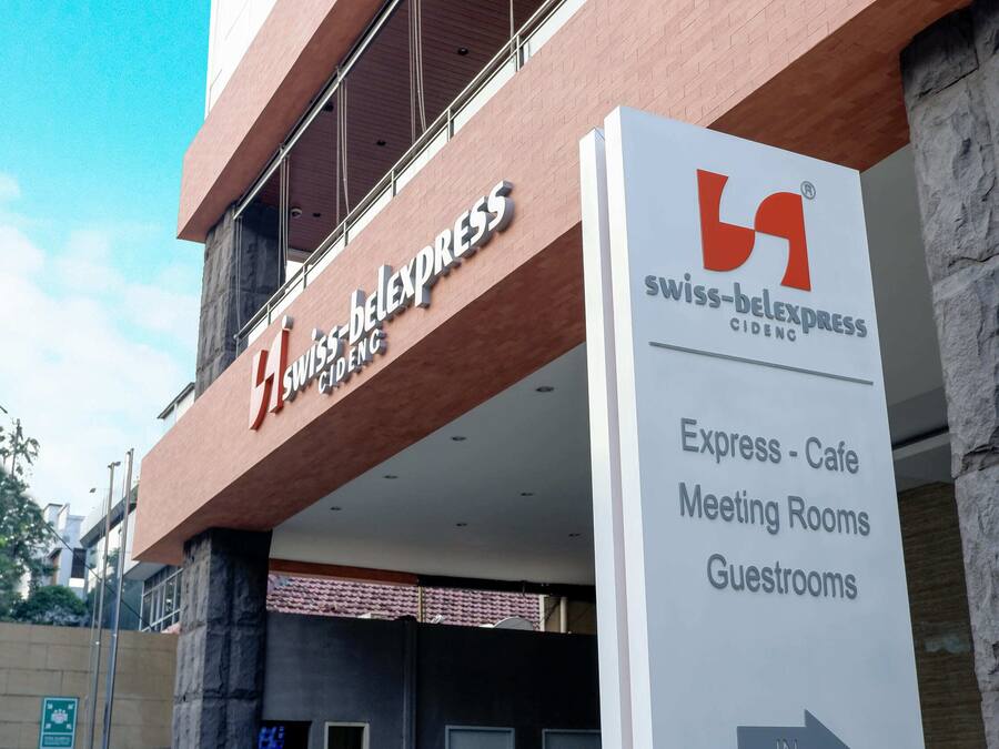 Entrada de hotel con señalización para Swiss-Belexpress CIDENG, indicando servicios como Express-Cafe, Salas de Reuniones y Habitaciones de Huéspedes.
