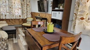 Ein Essbereich mit einem Holztisch, Stühlen und einer gelben Behälter für Besteck.