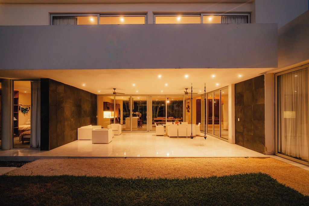 A modern house with a spacious patio, a dining area, and a living room with a fireplace.