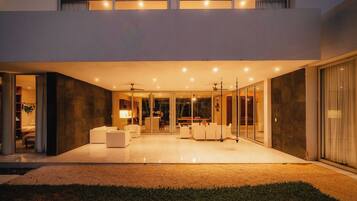 A modern house with a spacious patio, a dining area, and a living room with a fireplace.