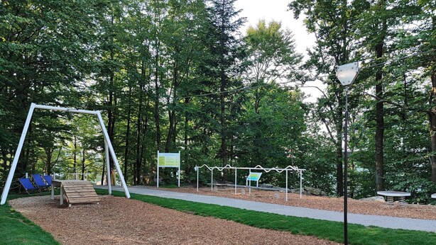 A park with a swing set, benches, and informational signs. - Appartement Peter in Freyung im Bayerischen Wald (Freyung)