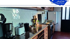A kitchen with a tiled backsplash, a coffee maker, a toaster, and wooden cabinets. - Holiday Home Casa Brisa Mar in Prazeres (Calheta)