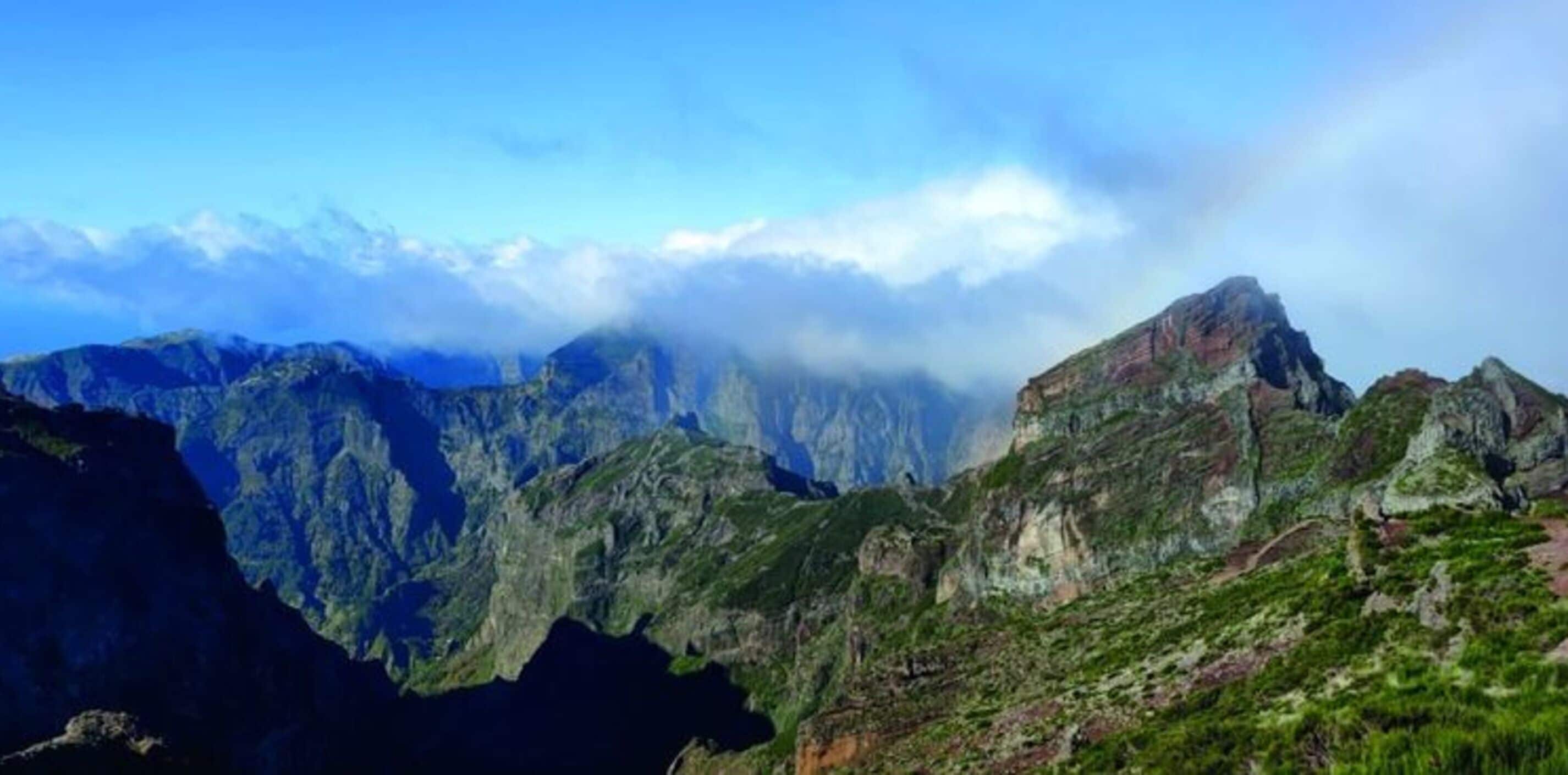 Un paisaje montañoso con terreno accidentado y un pico destacado.
