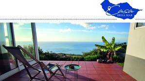 A balcony with a view of the sea, a chair, and a small table. - Holiday Home Casa Brisa Mar in Prazeres (Calheta)