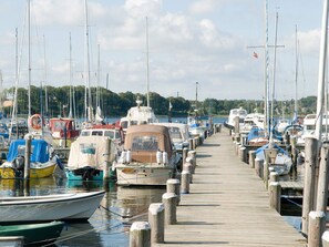 Un puerto deportivo con varias embarcaciones amarradas a lo largo de un muelle de madera.