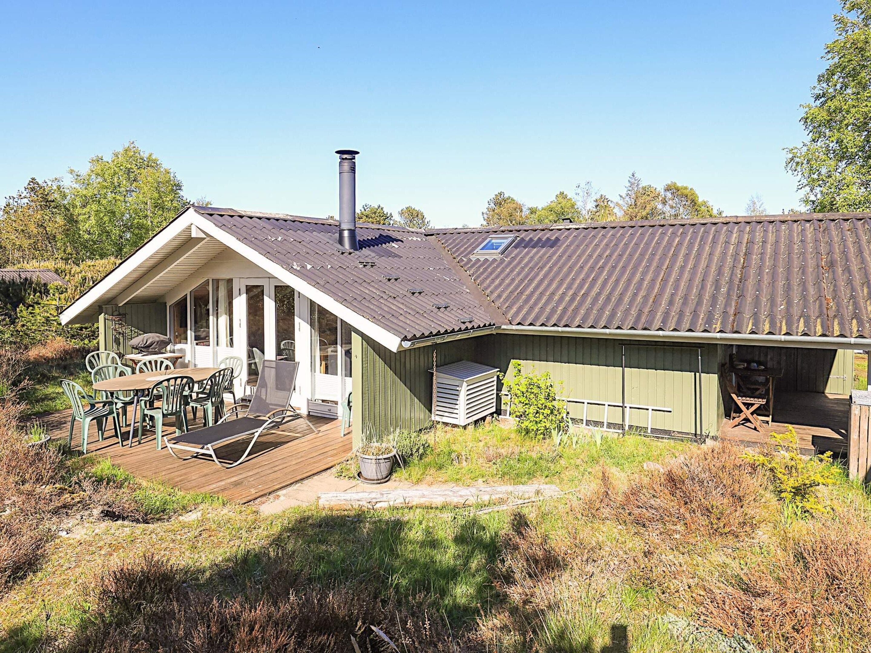 A house with a covered patio, a chimney, and a small garden.