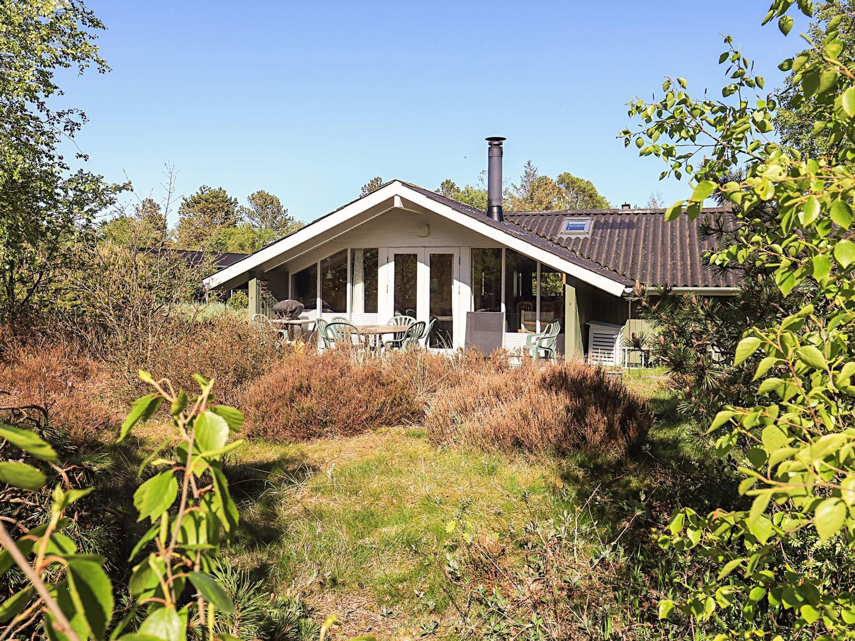 Una casa con portico, camino e giardino.