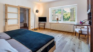 Makuuhuoneessa on sänky, työpöytä, televisio ja ikkuna, josta on näkymä vehreään maisemaan.