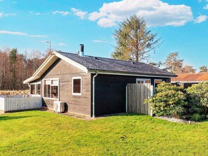 A single-story house with a sloped roof, a fenced yard, and a clear sky. - 5 Person Holiday Home in Hals (Hals)