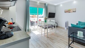 A modern apartment with a kitchen, dining area, and living space. - 523 center Playa las Americas, pool and wifi (Playa de las Américas)