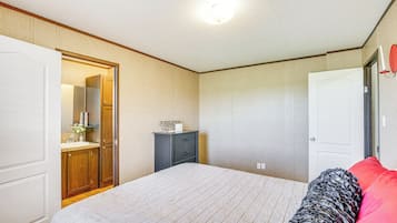 Un dormitorio con cama, cómoda, espejo y puerta.