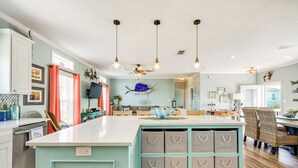 A spacious kitchen with a large island, pendant lights, and a ceiling fan. - 1 Mi to Marina: Rockport Vacation Rental (Rockport)
