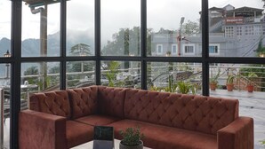 Un intérieur moderne avec une grande fenêtre, un canapé marron et une table basse en bois.