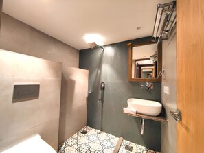 A bathroom with a shower, a sink, and a mirror. - Sangam by Stotrak (Dehradun)