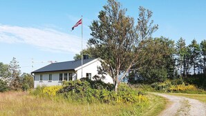 A house with a flagpole, surrounded by greenery and a gravel path. - 8 Person Holiday Home in Nordfold-by Traum (Steigen)