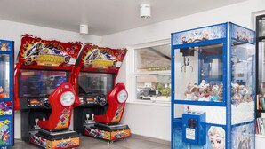 Zwei Spielautomaten, darunter ein Geschicklichkeitsarmspiel, und ein Fenster mit Blick auf eine Straße.