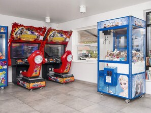 Zwei Spielautomaten, darunter ein Geschicklichkeitsarmspiel, und ein Fenster mit Blick auf eine Straße.