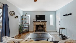 A living room with a brick fireplace, a television, and a coffee table. - Colorado Bay A & B (Colorado Springs)