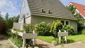 A house with a sloped roof, brick exterior, and a number '114' on the side.
