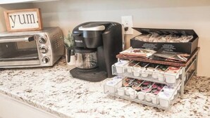 Eine Küchenarbeitsplatte mit einer Keurig-Kaffeemaschine, einem Toaster und einer Kapselbox.
