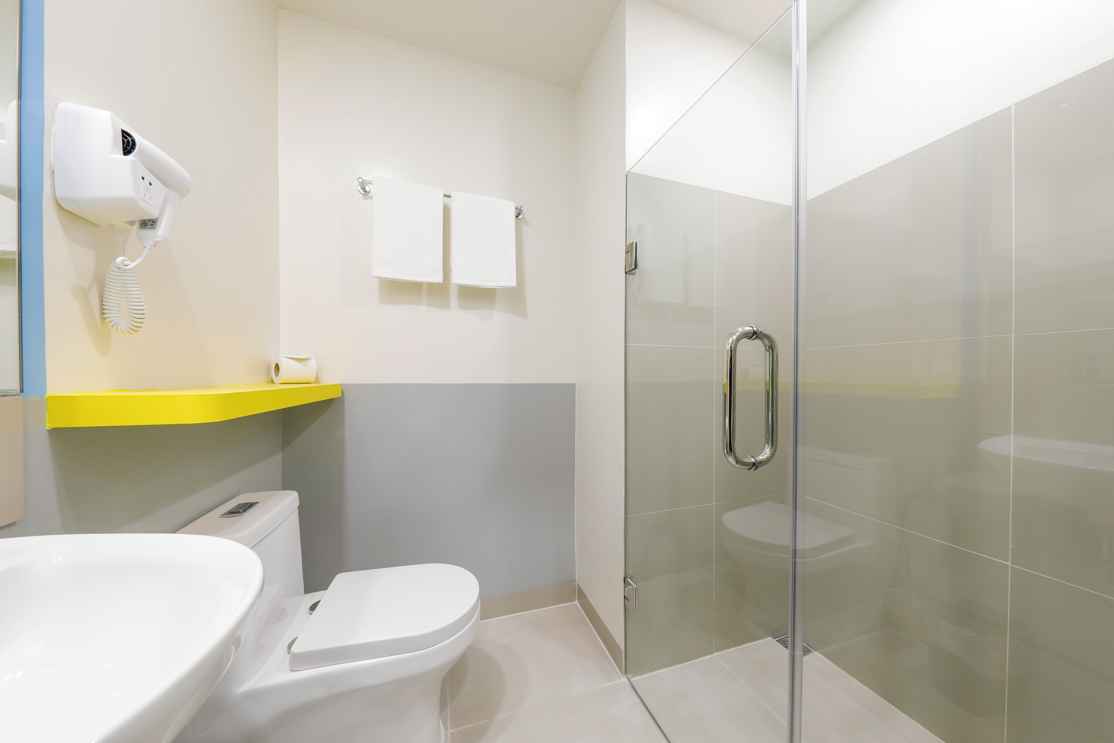 Un bagno moderno con servizi igienici, lavandino e box doccia in vetro.
