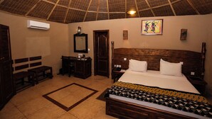 A room with a wooden bed, a desk, a chair, a bench, a mirror, and a ceiling fan. - Sogakope Beach Resort & Spa (Sogakope)
