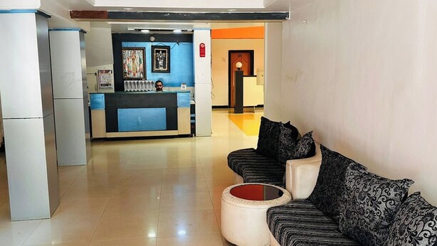 A hotel lobby with a reception desk, seating area, and a refrigerator. - Hotel Blue Heaven (Mahabaleshwar)