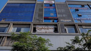 Un edificio de varios pisos con diversos comercios, incluyendo un hotel, una sucursal bancaria y un gimnasio.