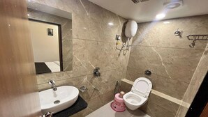 Un baño con lavamanos, inodoro y espejo.