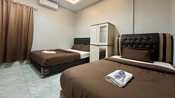 Een hotelkamer met twee bedden, een kledingkast en een airconditioning.