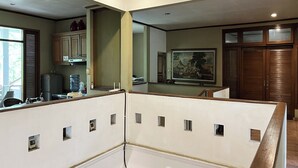 A room with a kitchen area, a dining table, and a large painting on the wall. - R Residence Jakarta (Jakarta)