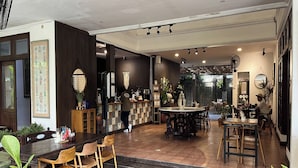 A spacious dining area with a central round table, surrounded by wooden chairs. - R Residence Jakarta (Jakarta)
