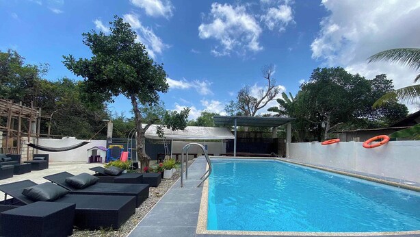A swimming pool with lounge chairs and a covered area. - Asiah'S Villa (Dauis)
