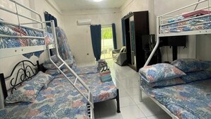A dormitory room with bunk beds, a television, and a wardrobe. - Asiah'S Villa (Dauis)