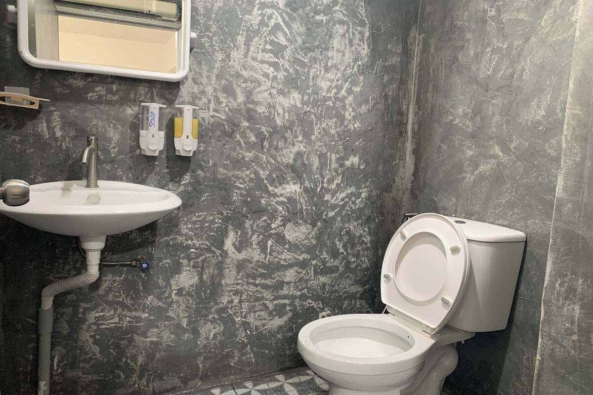 A bathroom with a white sink, a toilet, and a mirror above the sink.