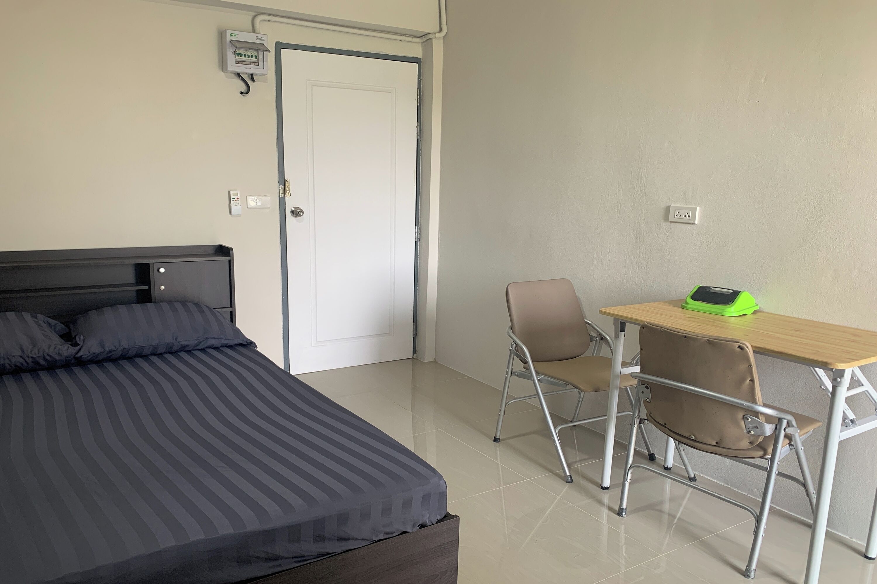 Un dormitorio con cama, escritorio y silla.