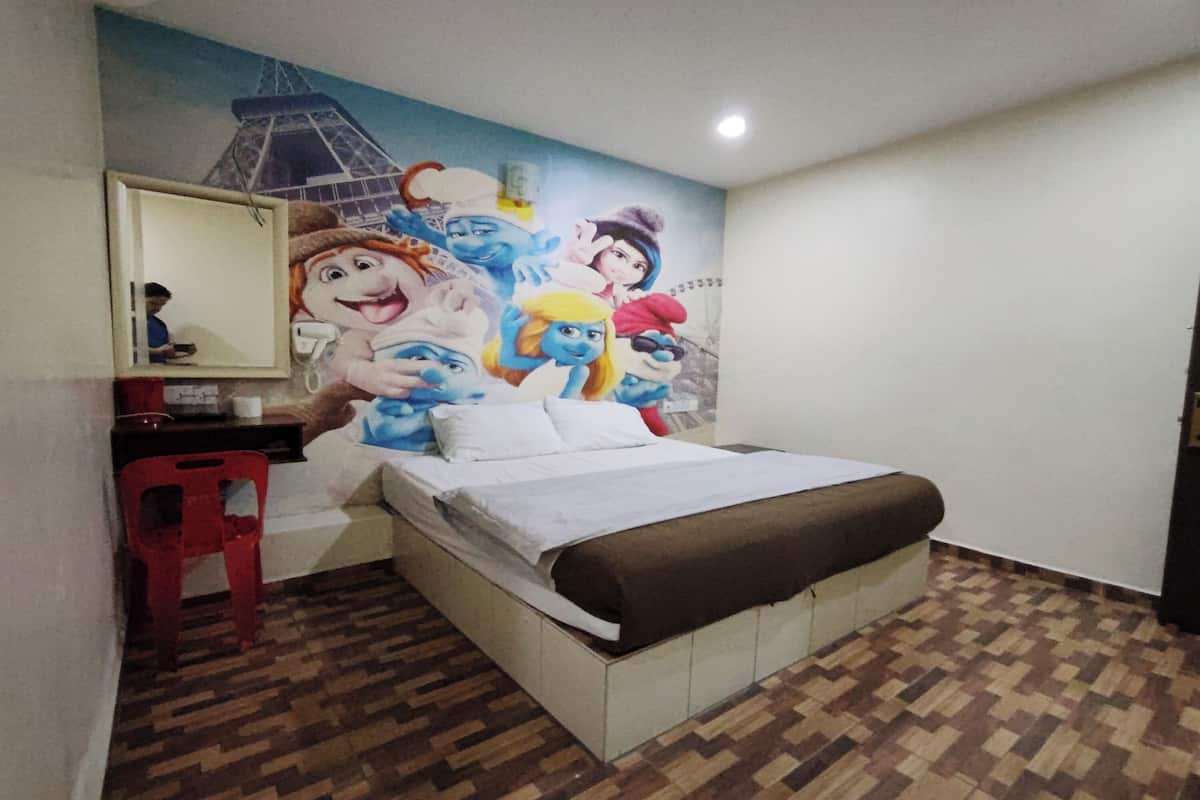 A bedroom with a bed, a red chair, a desk, and a wall mural.