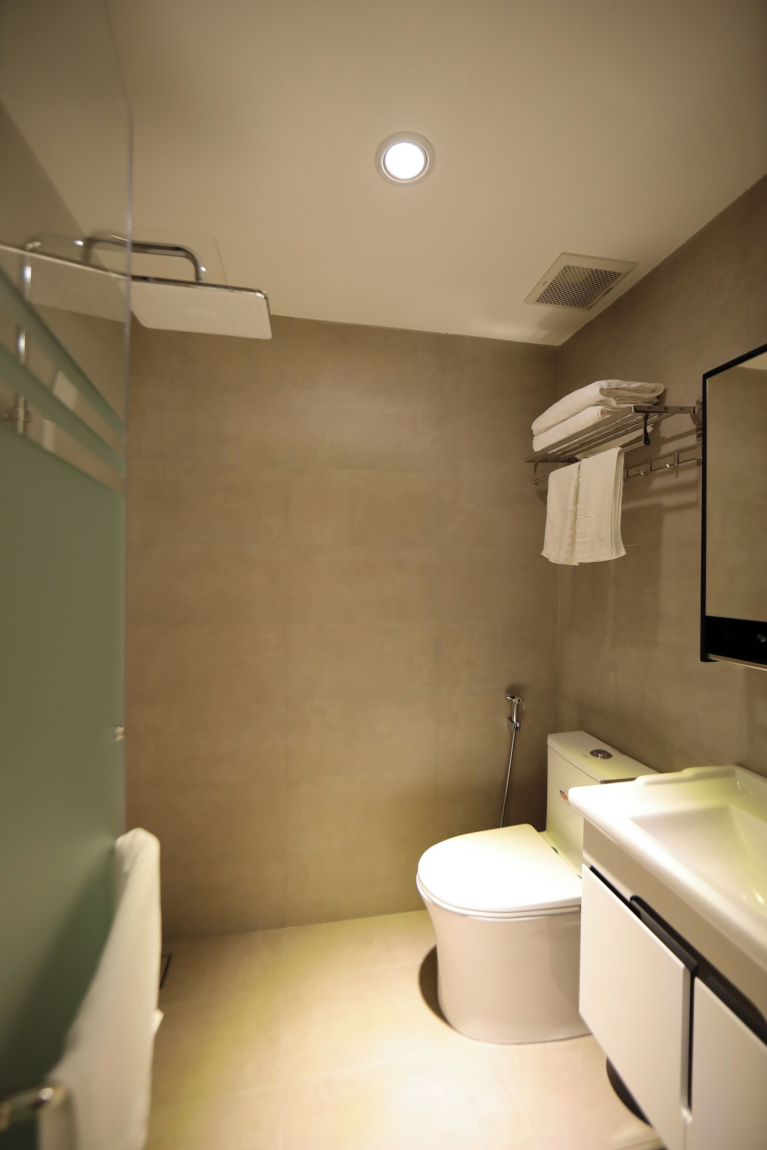 Un baño moderno con inodoro, lavamanos y ducha.