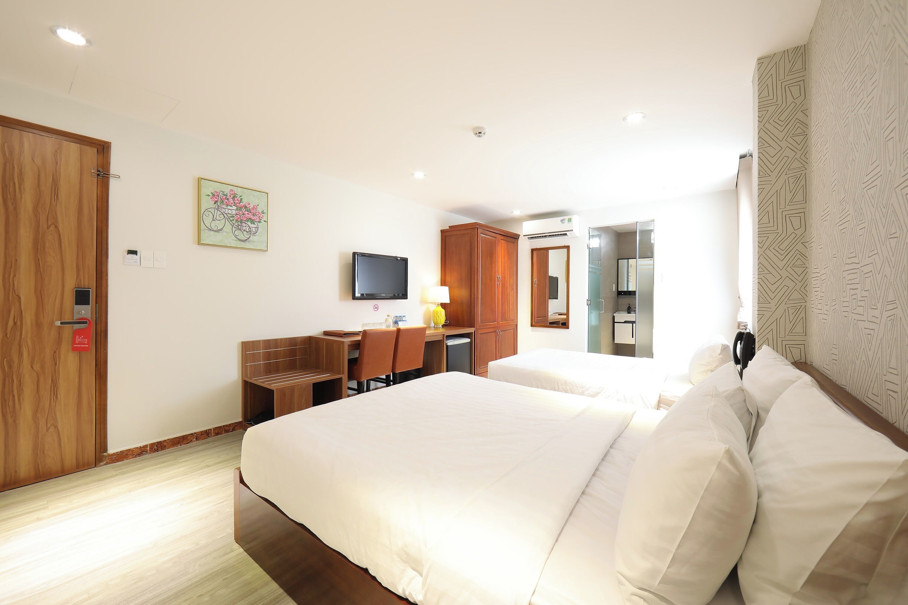 Una habitación de hotel con una cama grande, un escritorio con silla, un televisor y un armario.