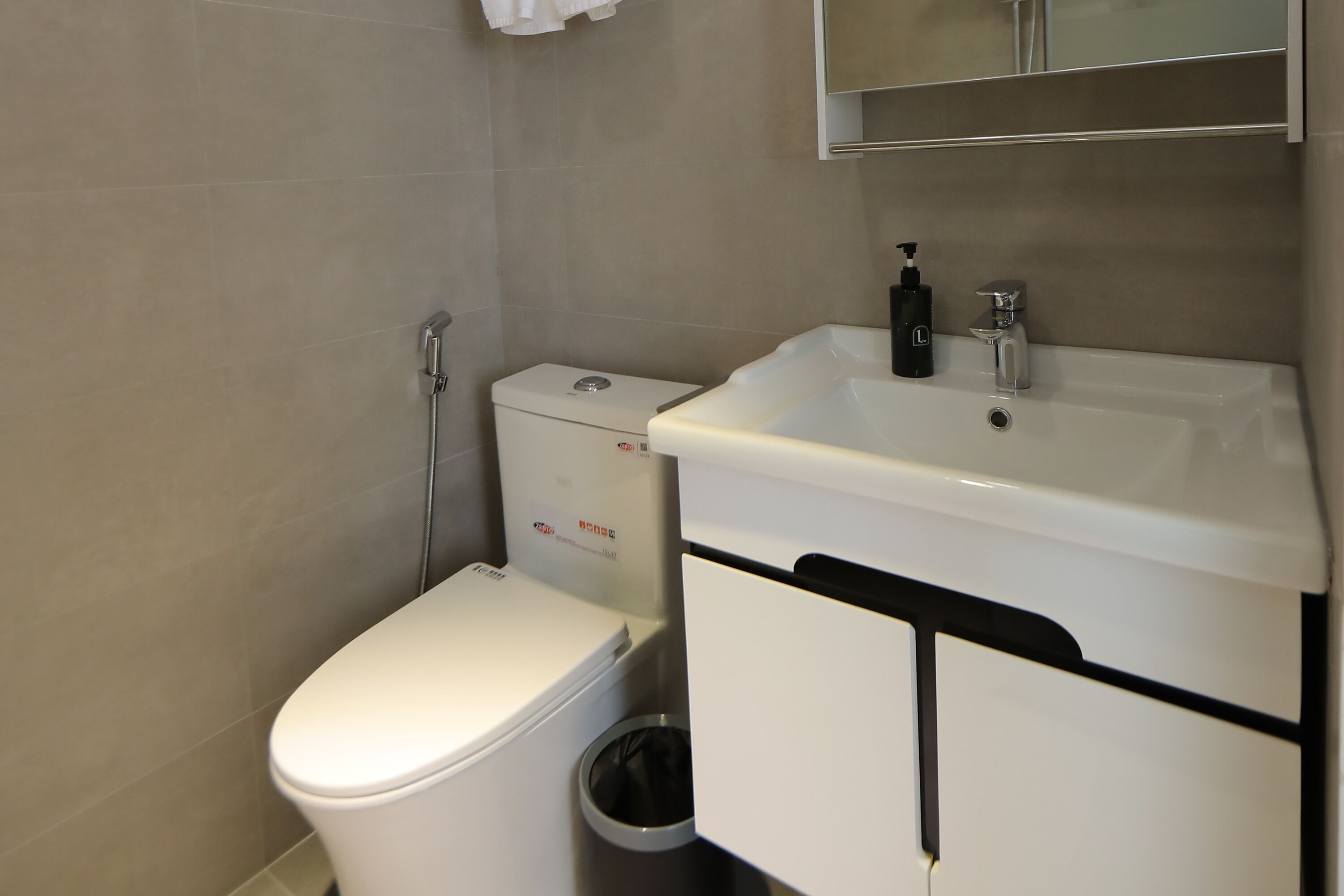 A modern bathroom with a toilet, bidet, and sink.
