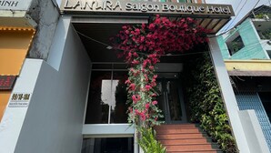 The entrance of the Lanara Saigon Boutique Hotel with a staircase and a large flowering plant. - Lanura Saigon Boutique Hotel (Ho Chi Minh City)
