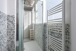 Regadera, secadora de cabello, toallas, papel de baño 
