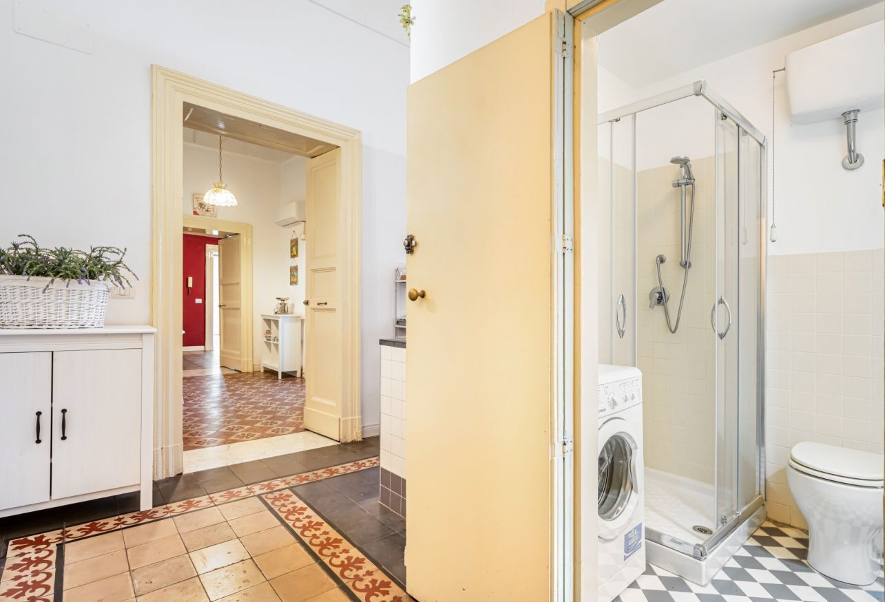 Une salle de bain d’hôtel équipée d’une douche, de toilettes et d’un lave-linge.