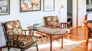 A room with two wooden chairs with floral upholstery, a small round table, and a floor lamp. - 6 Person Holiday Home in Skummeslovsstrand (Skummesloevsstrand)