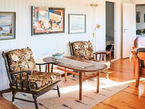 A room with two wooden chairs with floral upholstery, a small round table, and a floor lamp. - 6 Person Holiday Home in Skummeslovsstrand (Skummesloevsstrand)