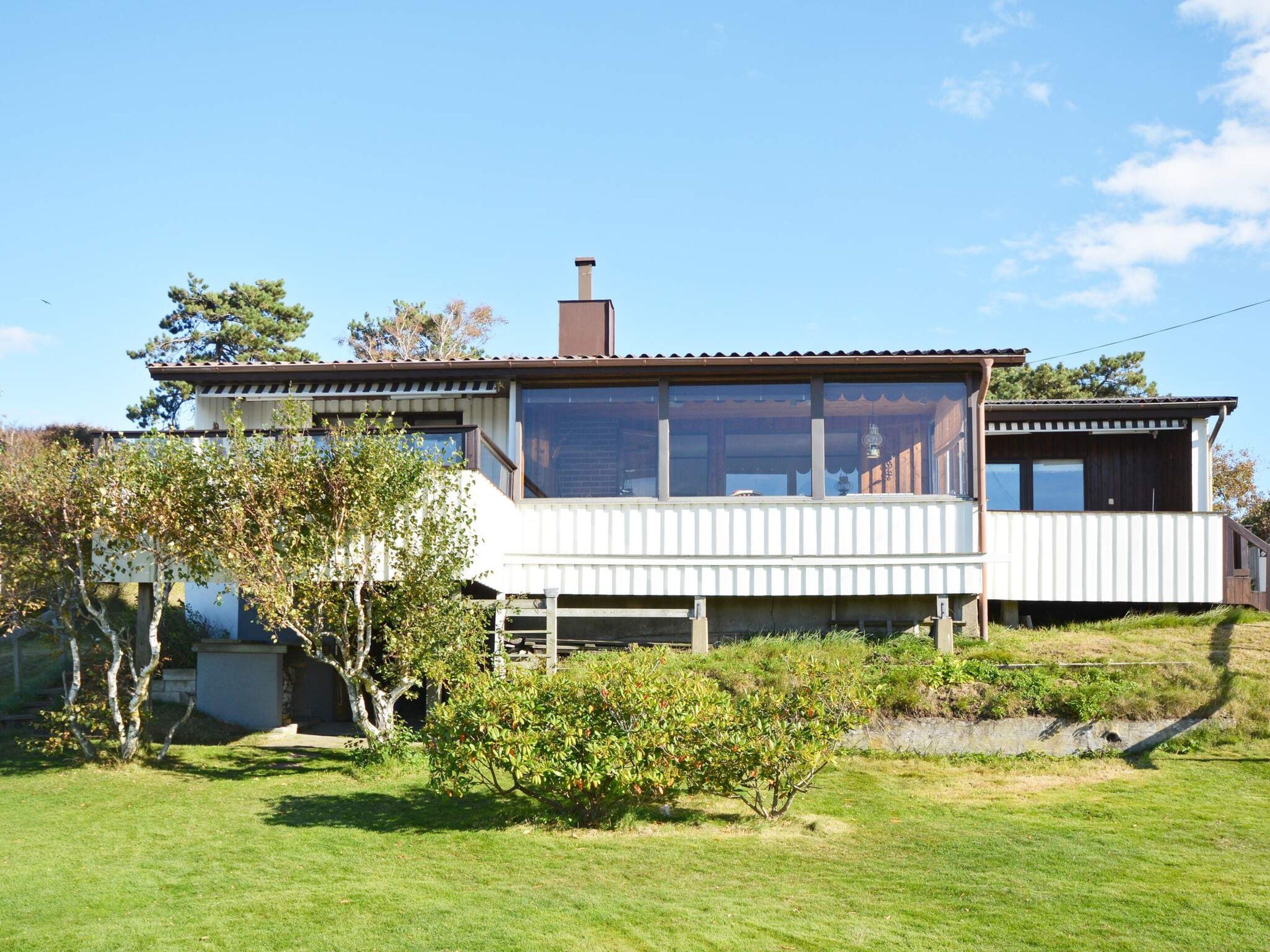 A two-story house with a balcony, a chimney, and a small garden.