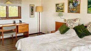 A bedroom with a wooden desk, a bed with green pillows, and wall art. - 6 Person Holiday Home in Skummeslovsstrand (Skummesloevsstrand)