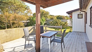 A wooden deck with a table and chairs, surrounded by a wooden fence and trees. - 6 Person Holiday Home in Skummeslovsstrand (Skummesloevsstrand)